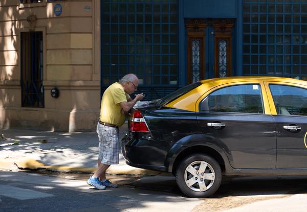 A taxi driver has lunch at  his taxi. Buenos Aires, Argentina. 2020.